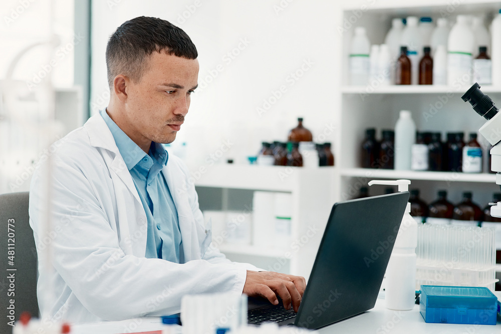 Keep calm, the cure is coming. Shot of a young scientist using a laptop while working in a laborator