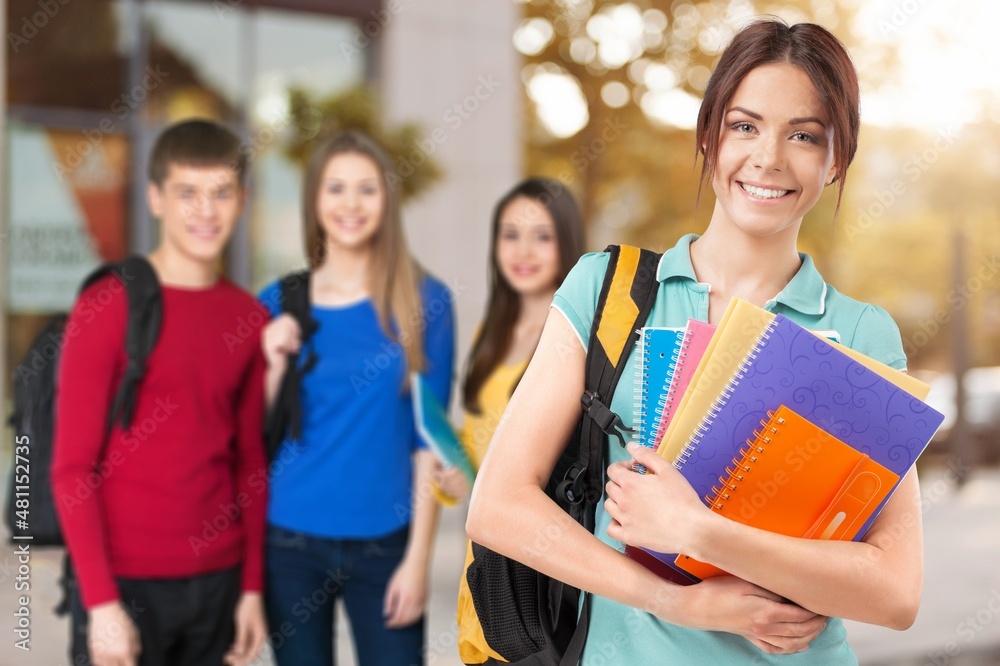 Laughing female student with group of multi ethnic young adults outdoor in city