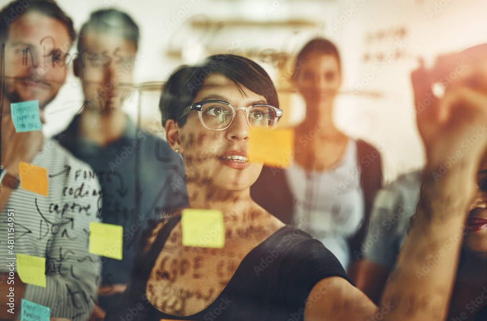 Exploring new possibilities. Cropped shot of a group of young designers using sticky notes during a 