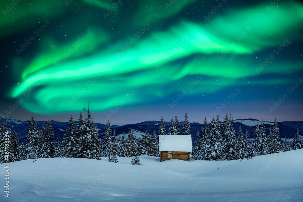 雪山中的木屋和夜空中的北极光，令人惊叹的冬季景观。克里