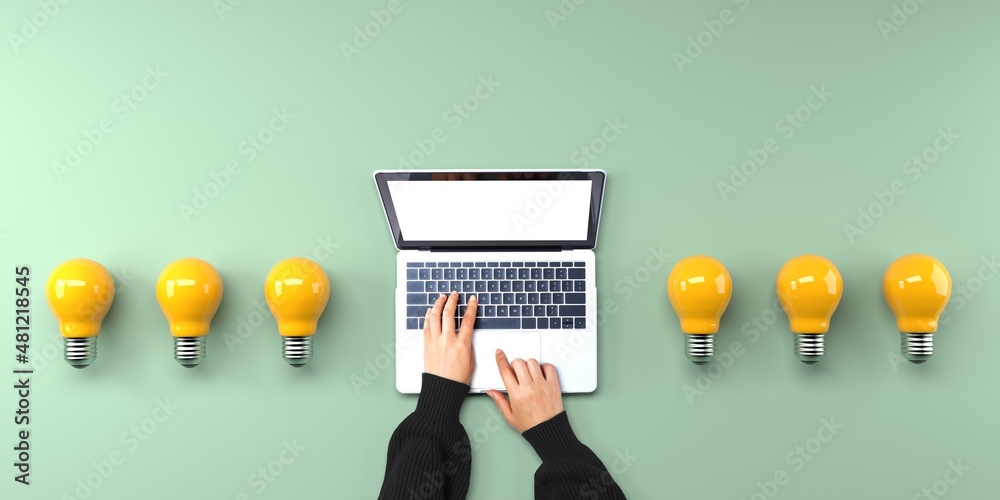 Person using a laptop computer with light bulbs from above