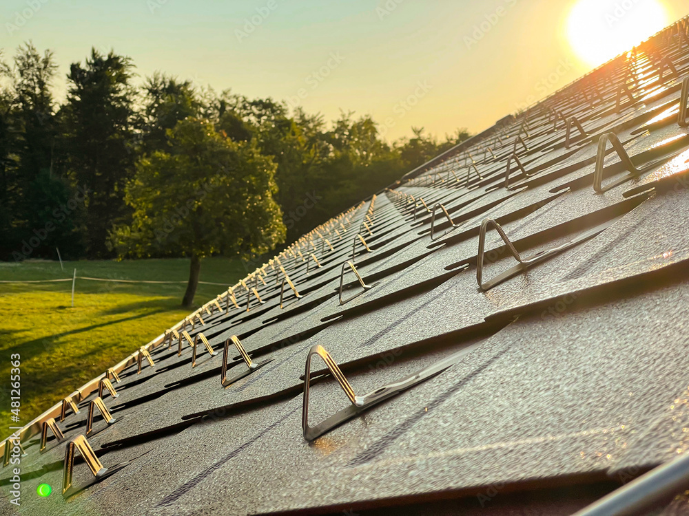 CLOSE UP: Sunset illuminates the snow guards installed on the renovated roof.