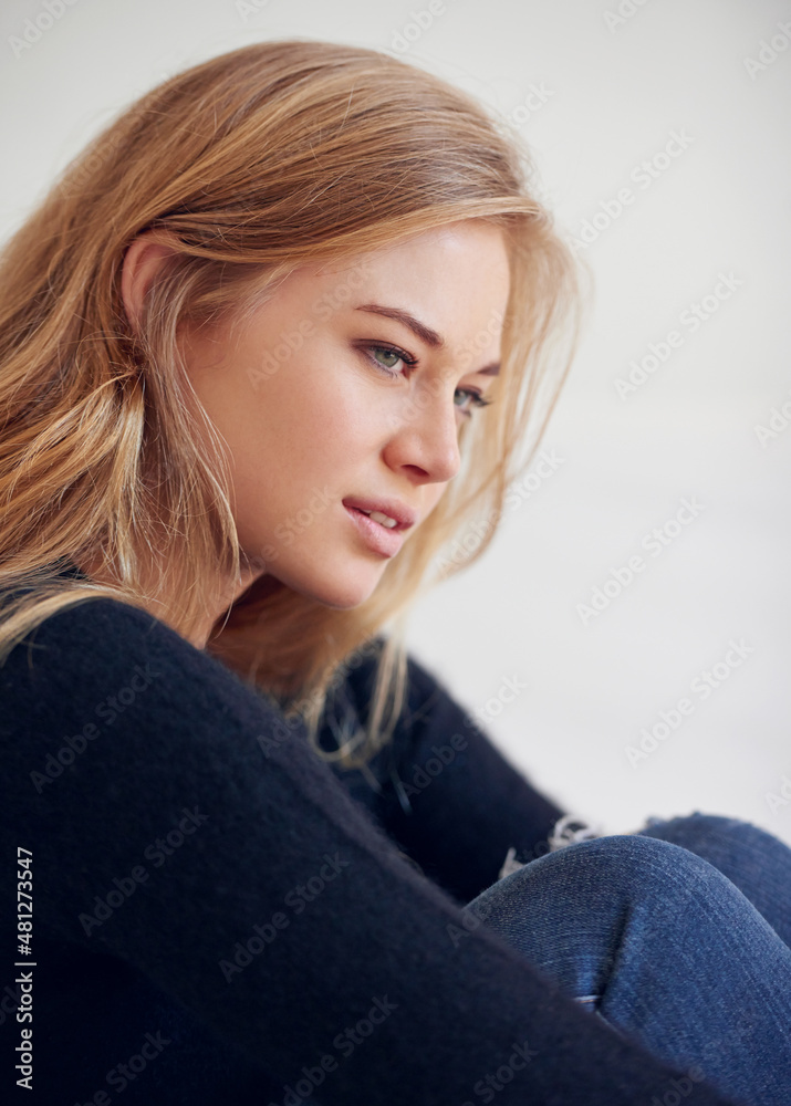 I think in black. Shot of a beautiful young woman sitting on her bedroom floor.