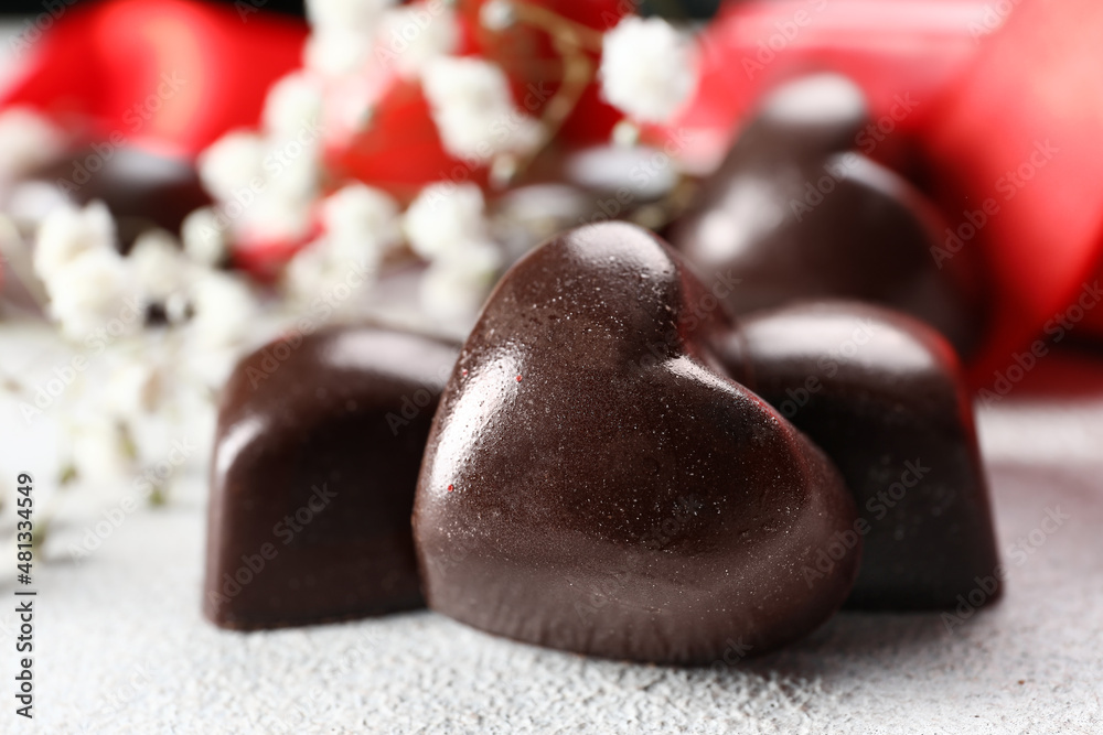 Tasty heart-shaped candies on light background, closeup