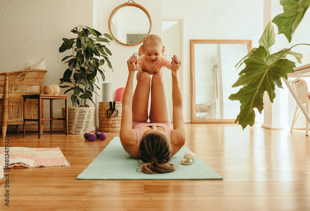 Yogi mom lifting her adorable baby with her legs