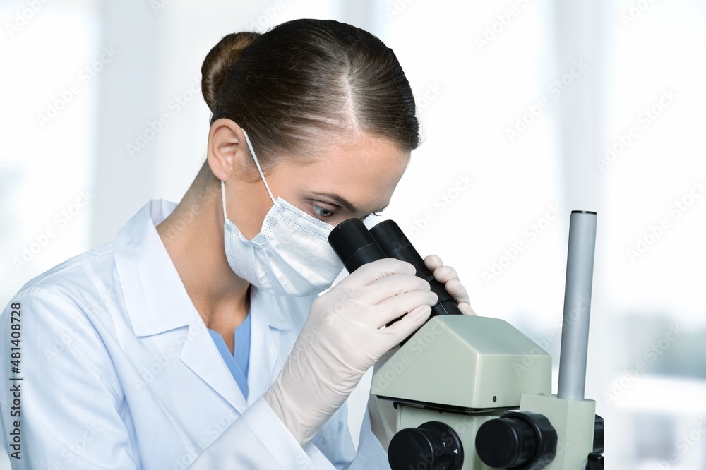 Young Scientist Looking a Petri Dish with Genetically Modified Sample Chemicals Under a Microscope.