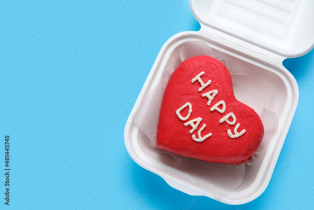 Plastic lunch box with tasty bento cake on blue background