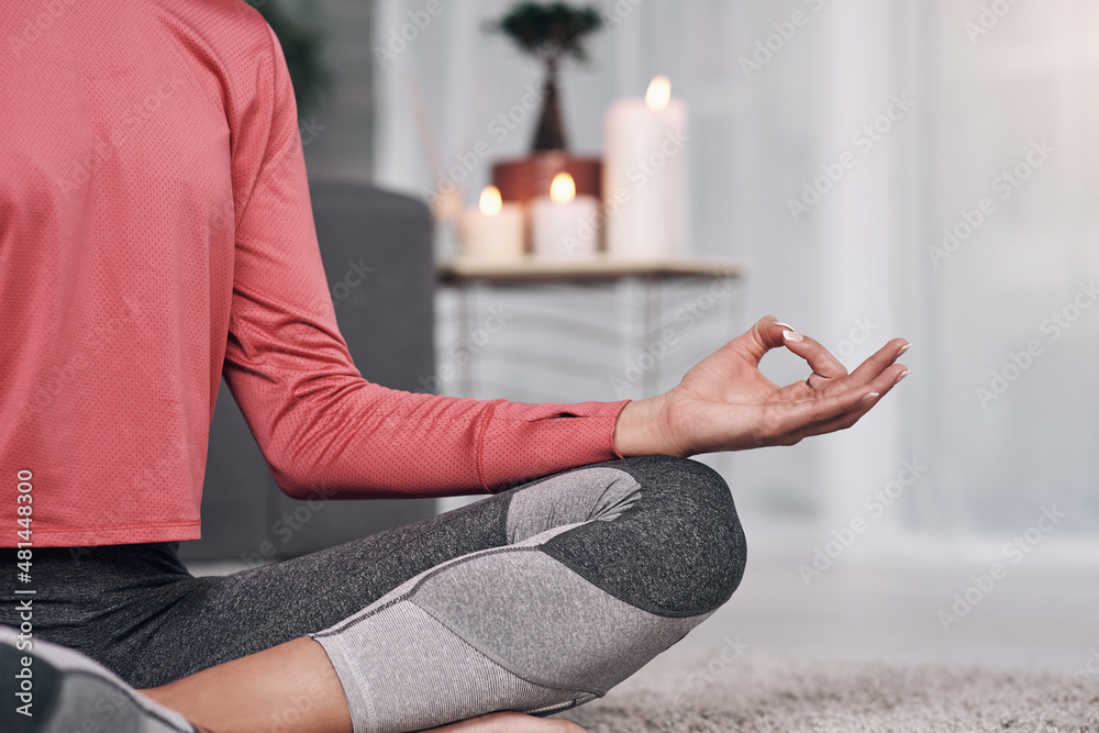 Peace cannot be televised. Shot of an unrecognizable woman meditating on the lounge floor home.