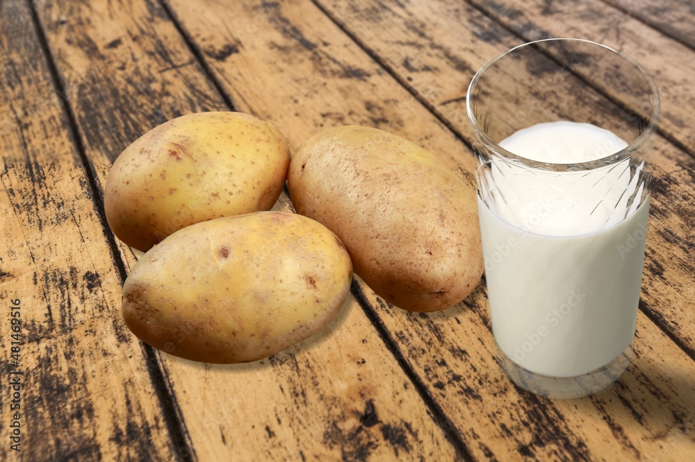 Concept of potato milk on the table with the potato tubers. A new trend in healthy eating. Alternati