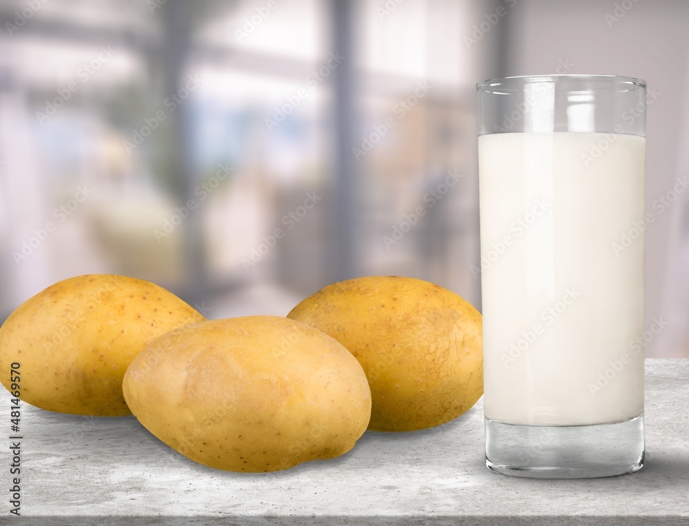 Concept of potato milk on the table with the potato tubers. A new trend in healthy eating. Alternati