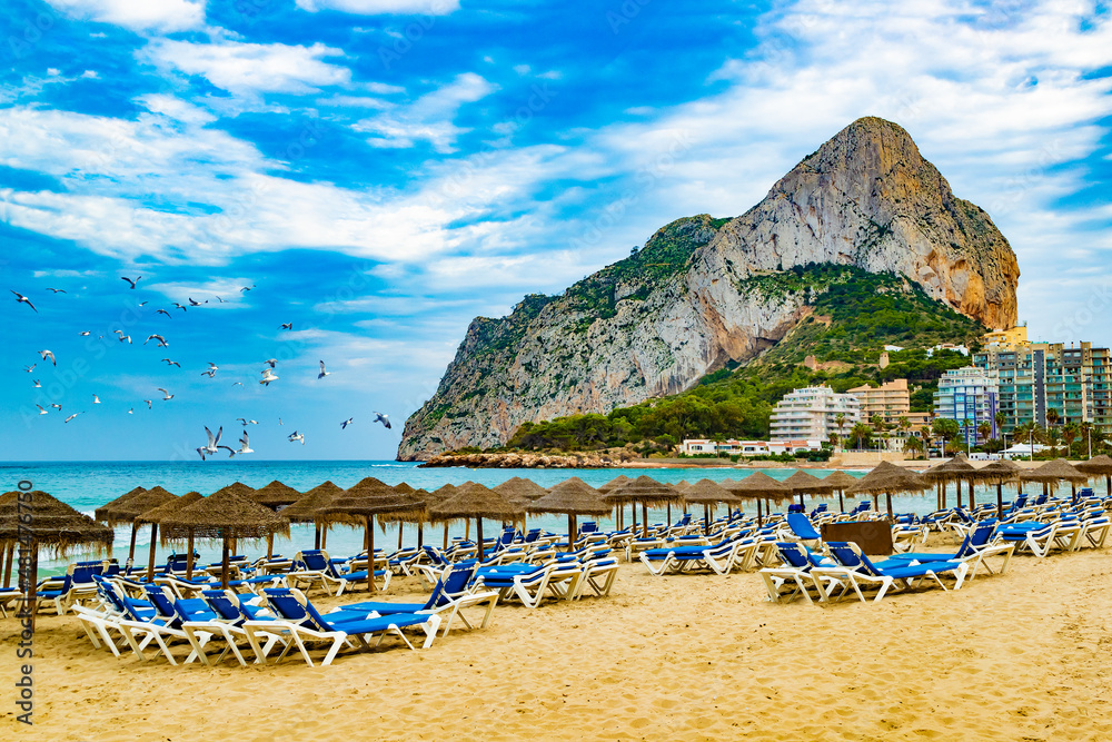 Puesta de sol en la playa de España. Roca del Peñón de Ifach. Paisaje de la costa mediterránea en la