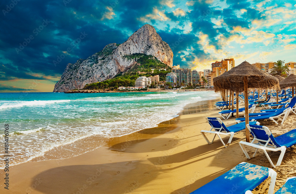 Puesta de sol en la playa de España. Roca del Peñón de Ifach. Paisaje de la costa mediterránea en la