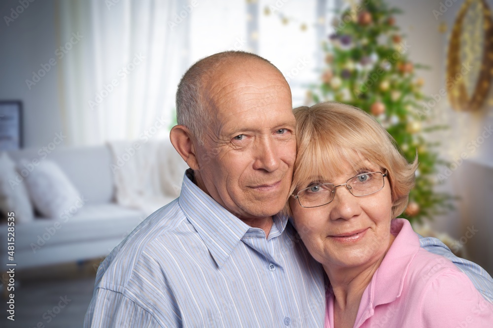 old retired age couple watching TV at home, on sofa couch at living room home