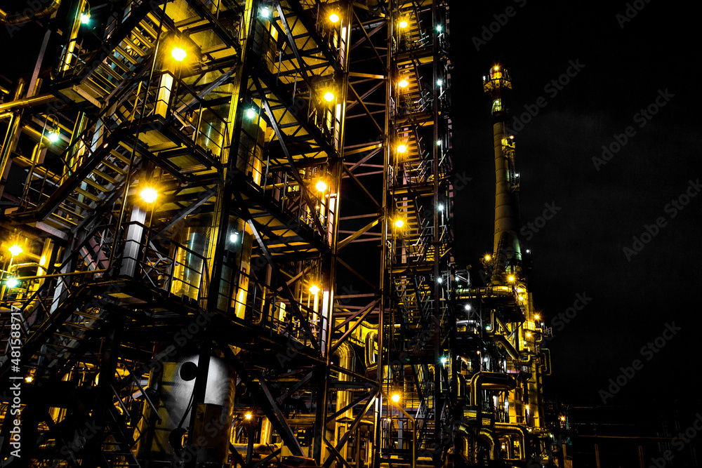 Refinery pipes and buildings at night - big factory lights