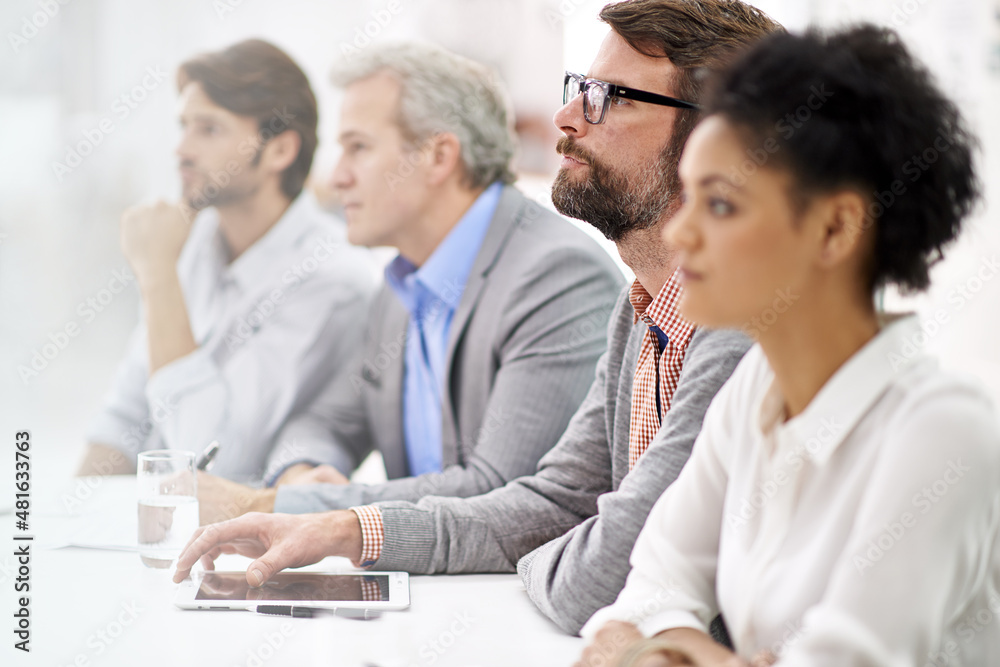 Project debriefing. Shot of a group of dedicated business professionals sitting in a row.