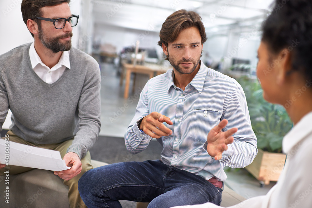 Running through the contracts details. Shot of a group of young professionals discussing paperwork.