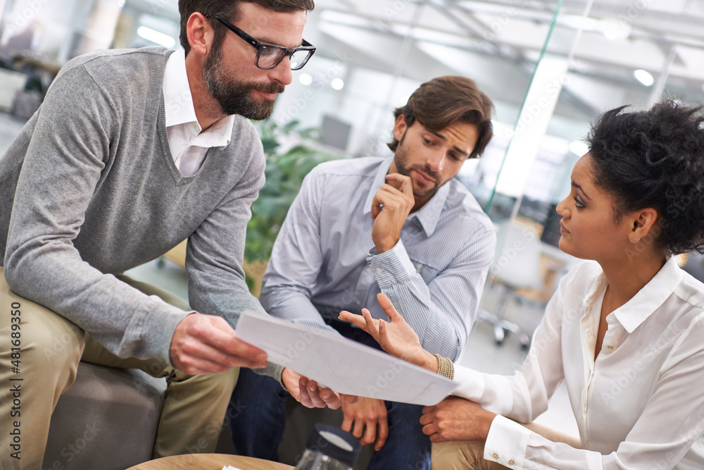 Running through the contracts details. Shot of a group of young professionals discussing paperwork.