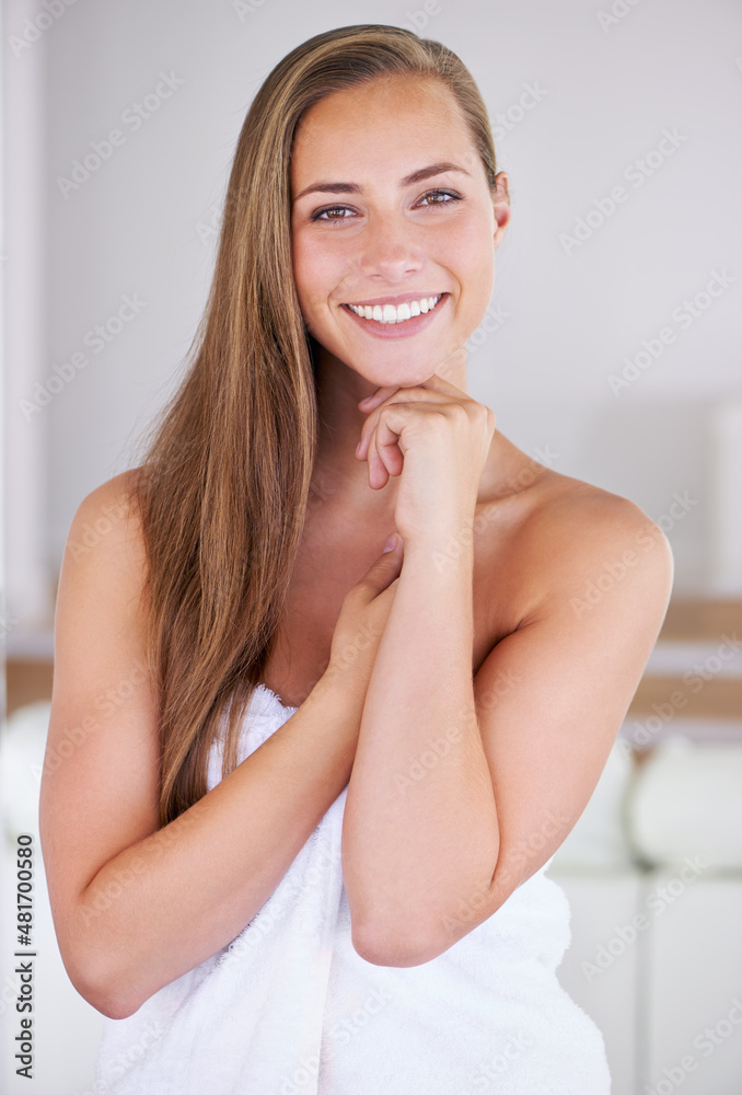 Soft and supple skin. Confident brunette woman posing in a towel.