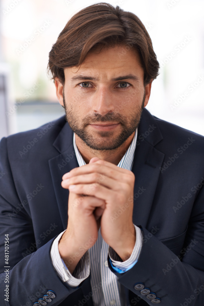 The time to succeed is now. Portrait of a handsome man sitting at a desk in an office.