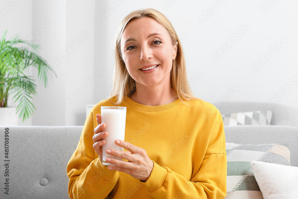 Mature woman with glass of milk at home