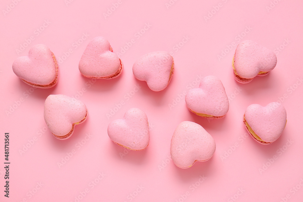 Tasty heart-shaped macaroons on pink background