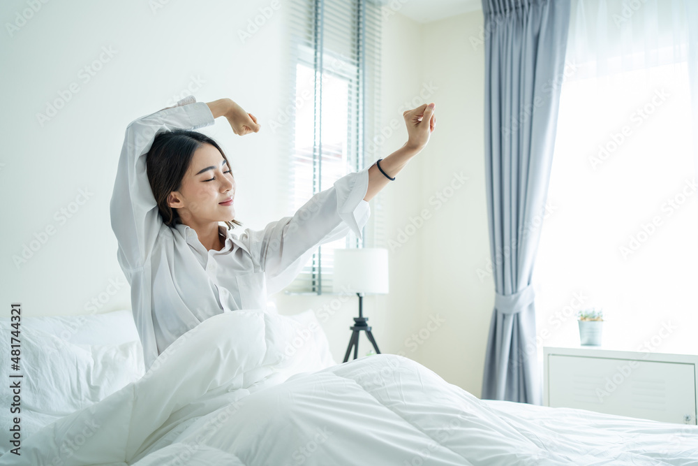 Asian beautiful girl in pajamas wake up in the morning with happiness. 