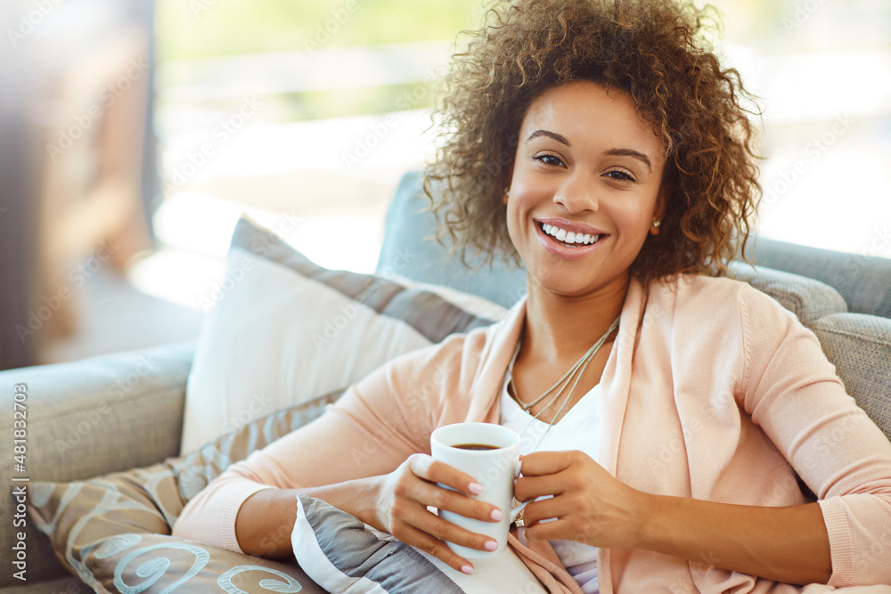 Tea time is me time. Portrait of a young woman relaxing with a warm beverage at home.