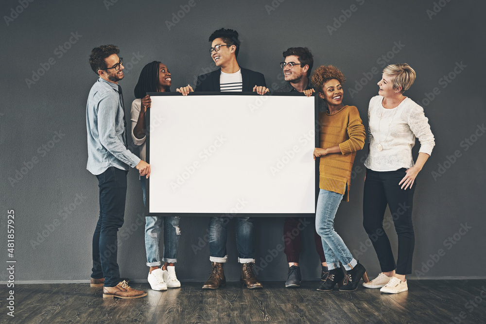 Market your idea here. Studio shot of a diverse group of people holding up a placard against a grey 