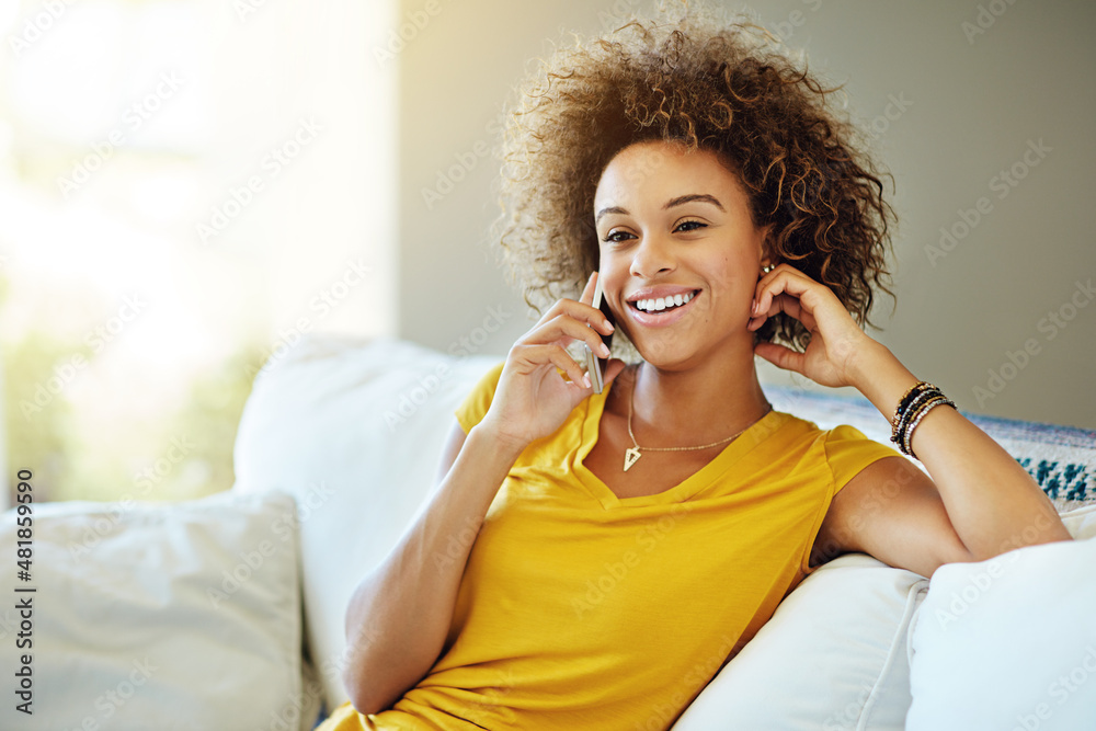 Just chilling at home this weekend. Shot of a young woman talking on her phone on a relaxing day at 