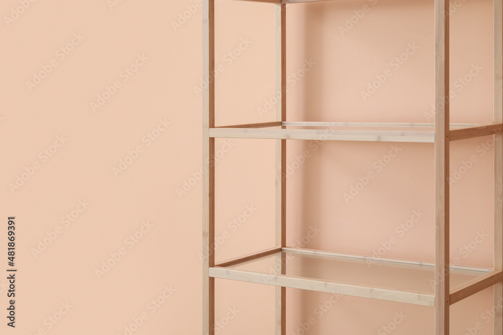 Empty wooden shelving unit near pink wall