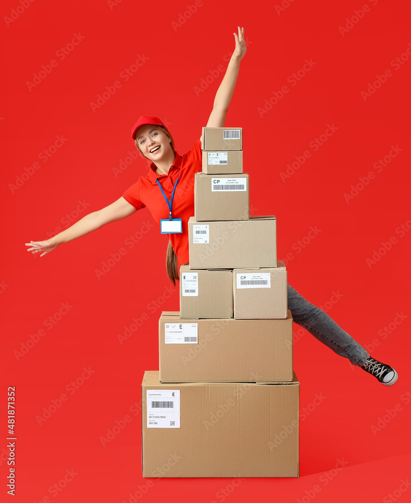 Female courier with many parcels on color background