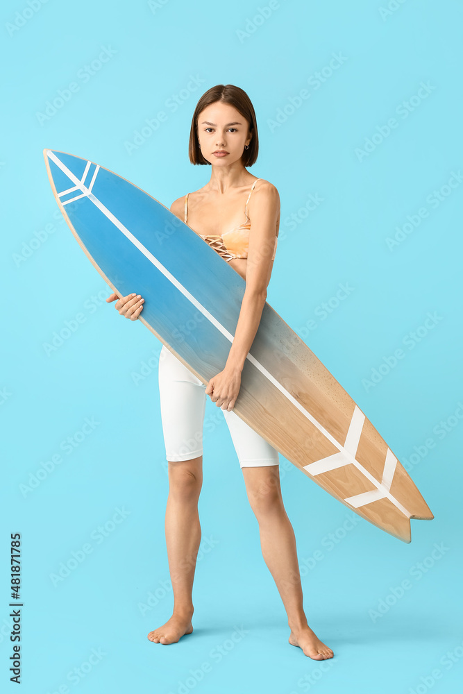 Beautiful young woman with surfboard on color background