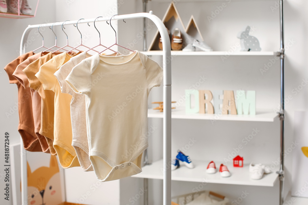 Rack with baby bodysuits in light childrens room