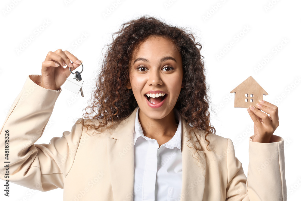 Happy African-American real estate agent with figure of house and key on white background