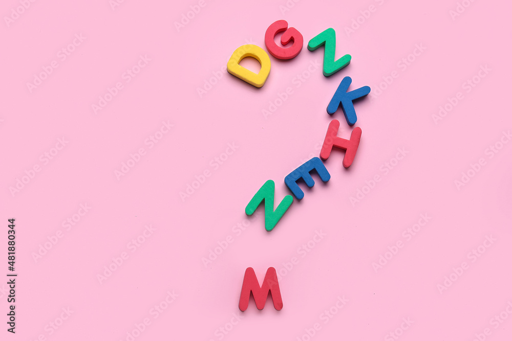 Question mark made of colorful letters on pink background