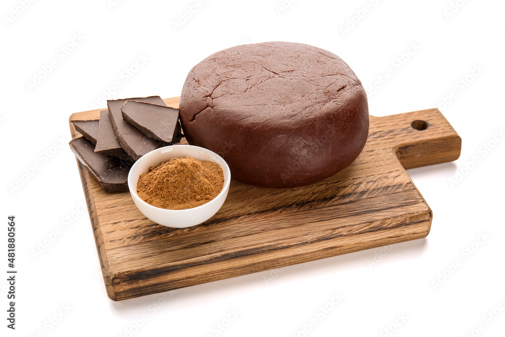 Wooden board with dough, chocolate and bowl of cinnamon powder on white background