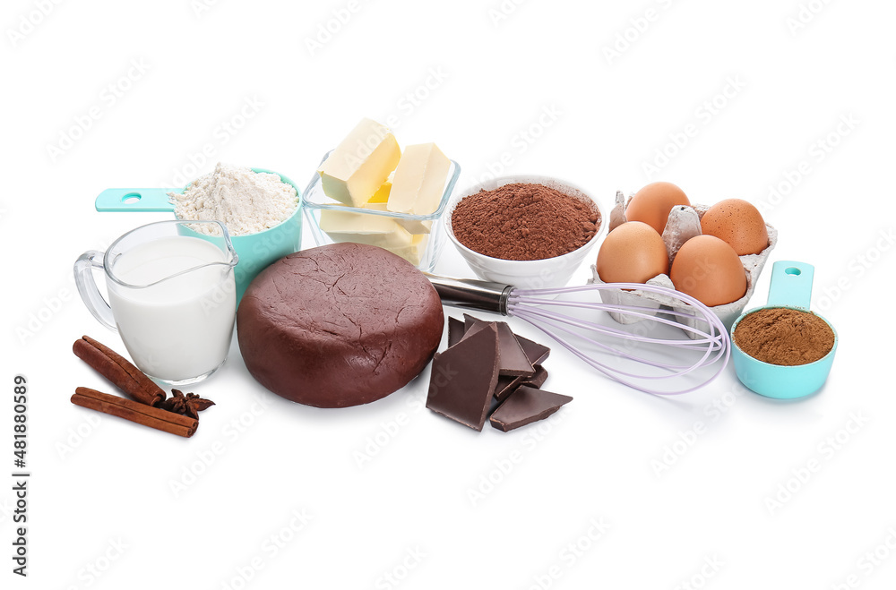 Ingredients for preparing tasty cookies and whisk on white background