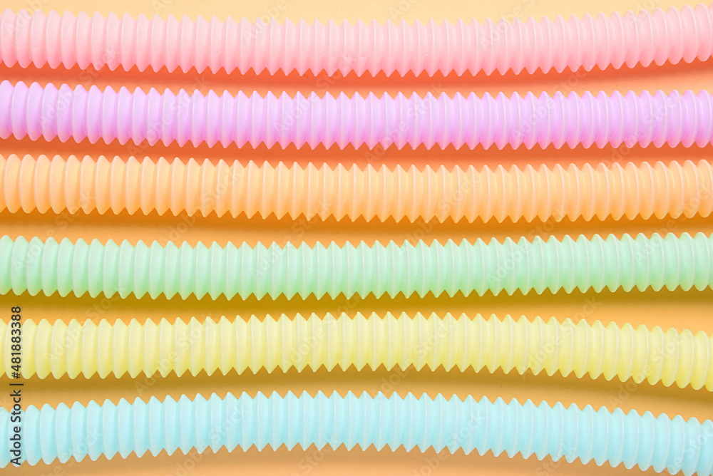 Different colorful Pop Tubes on color background