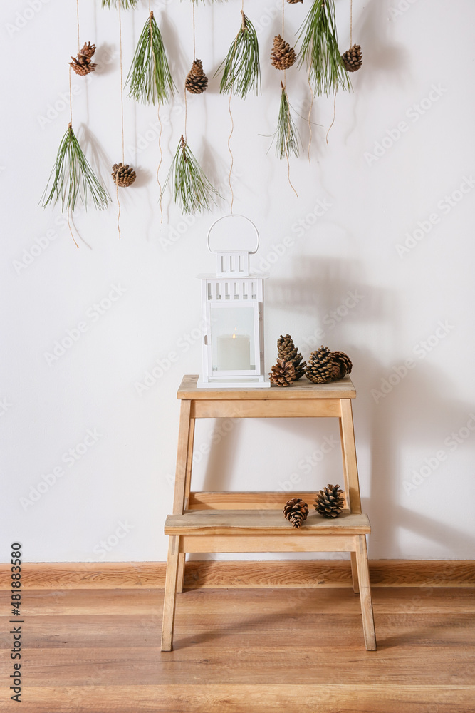 Step ladder with candle and pine cones in room