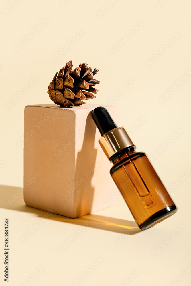 Composition with bottle of essential oil and cone on color background