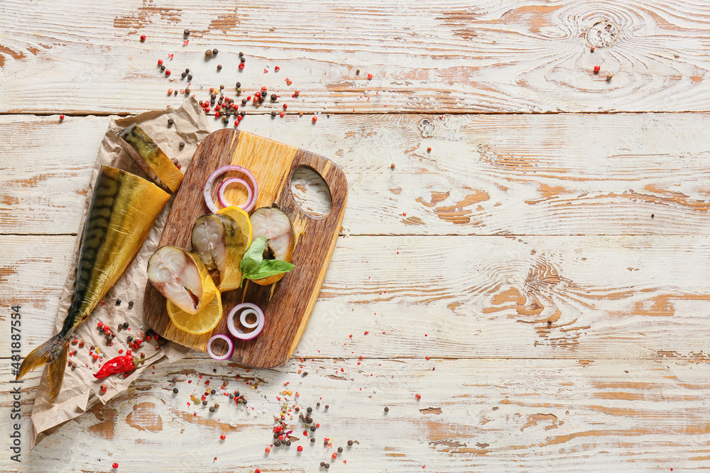 Board with cut smoked mackerel fish on white wooden background