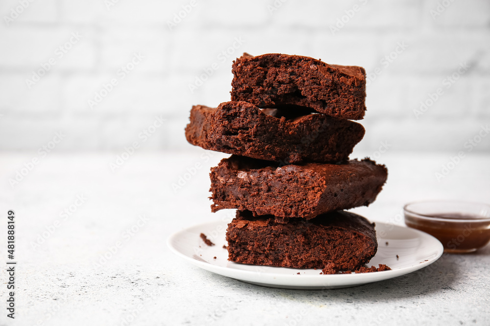 Plate with pieces of tasty chocolate brownie on table