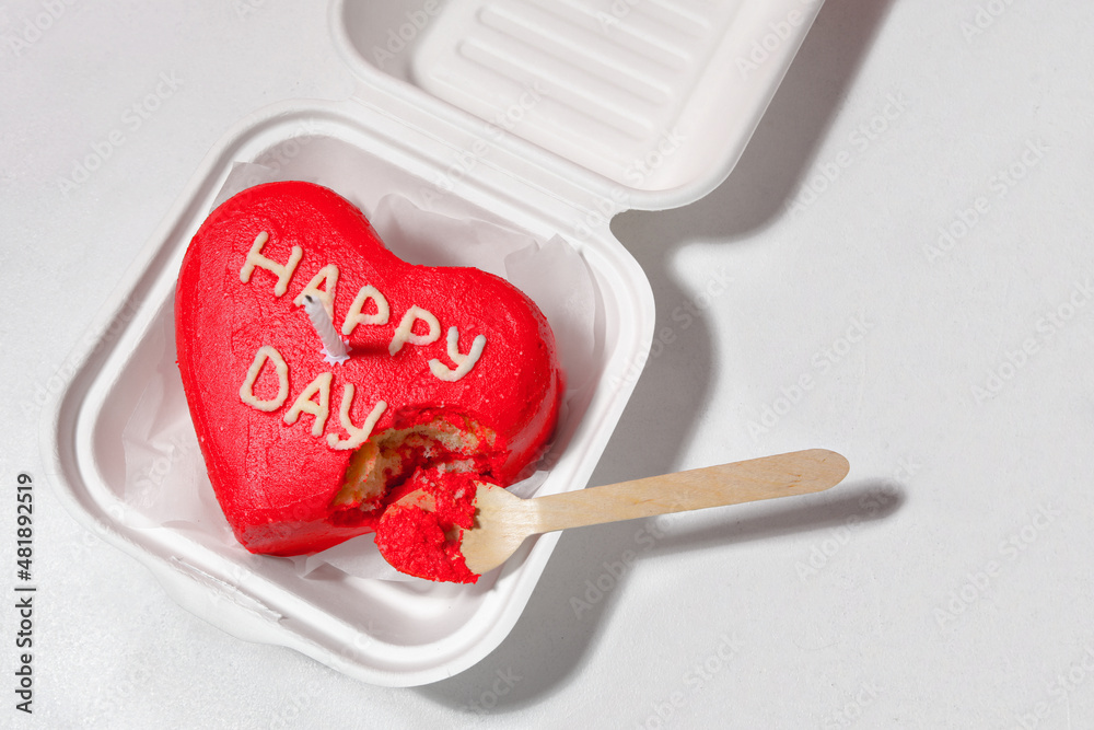 Plastic lunch box with tasty bento cake and candle on light background