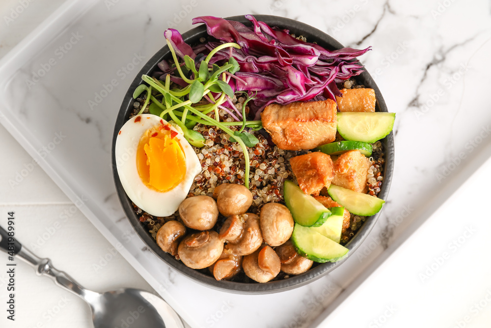 Healthy quinoa bowl with egg and meat on tray