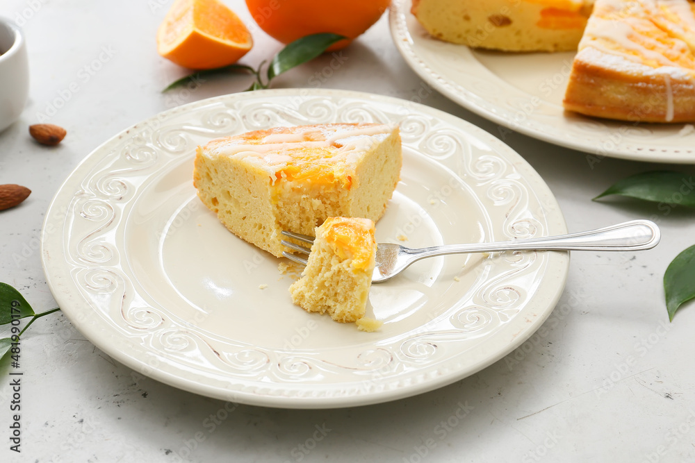 Plate with slice of tasty citrus cake with oranges on table