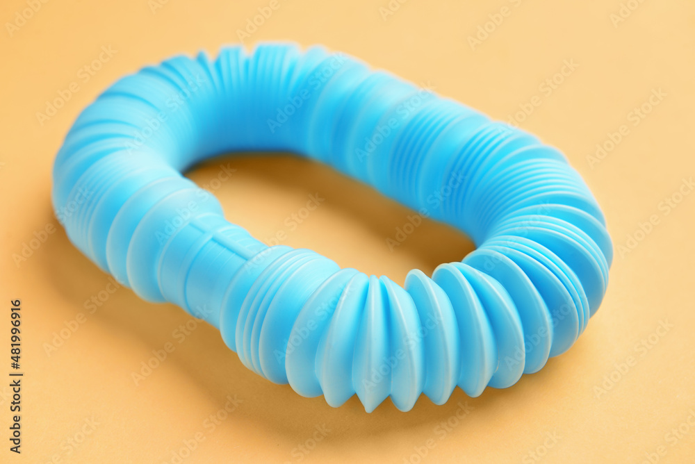 Blue Pop Tube on orange background, closeup