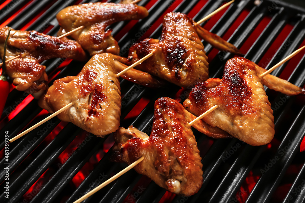 Tasty chicken wings skewers on grill