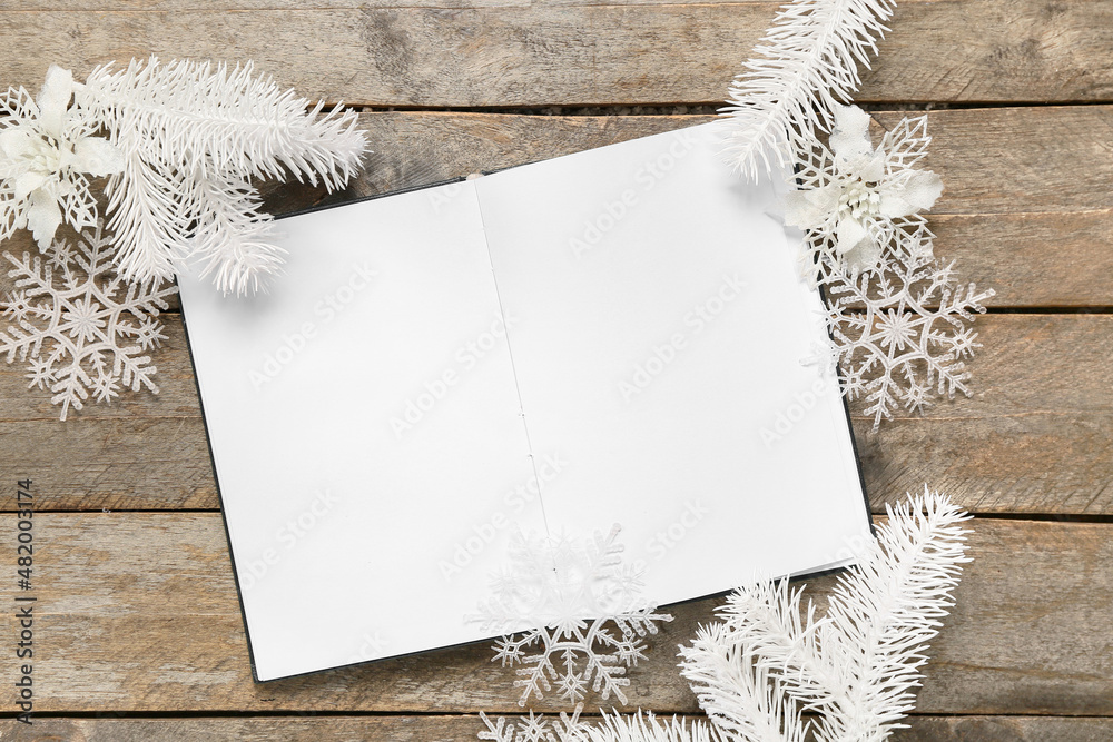 Opened book with blank pages and beautiful winter decor on wooden background