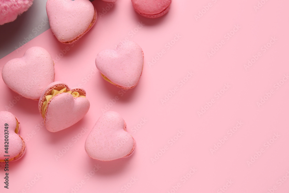 Tasty heart-shaped macaroons on color background