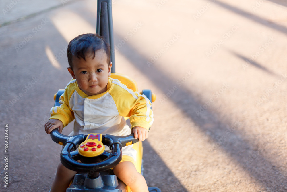 Kid sit in the stroller to walk in the park